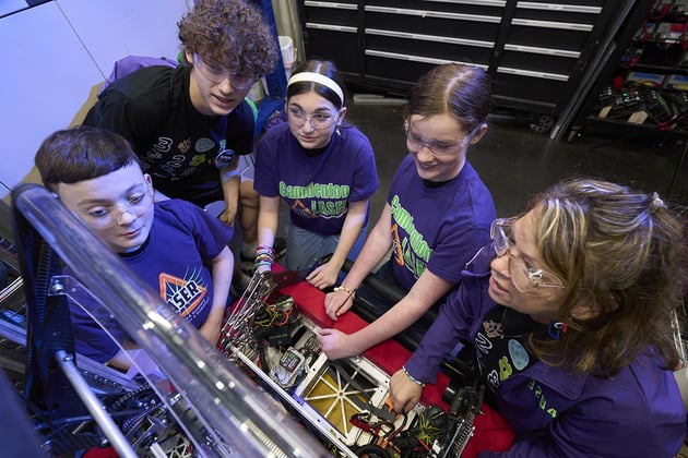 FIRST team examining their robot